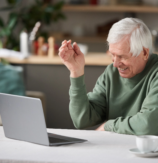 Senior man taking online Greek classes on his laptop